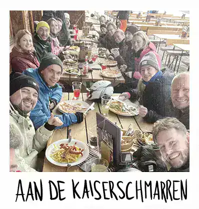 Groep mensen aan tafel op wintersport