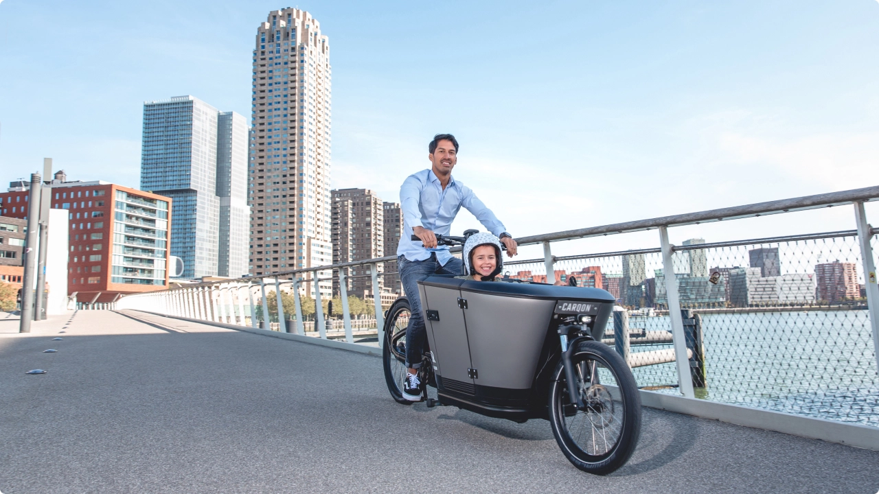 Afbeelding van man met een fietsvoordeelshop.nl bakfiets en zijn zoon